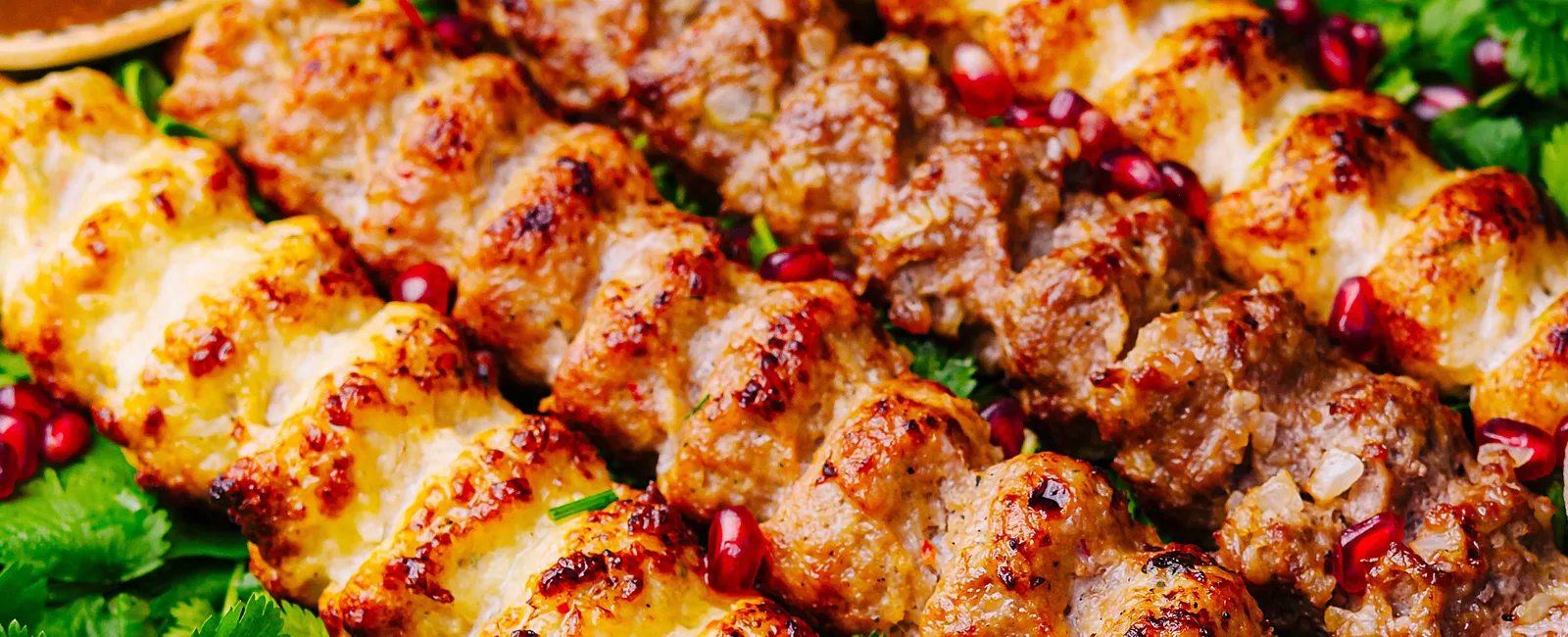 Grilled chicken and meat kabob skewers with herbs and pomegranate