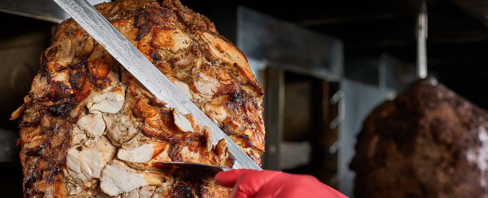 Chicken shawarma carved from a vertical rotisserie