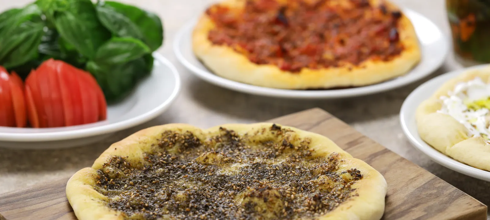 Zaatar flatbread with fresh herbs on a wooden board